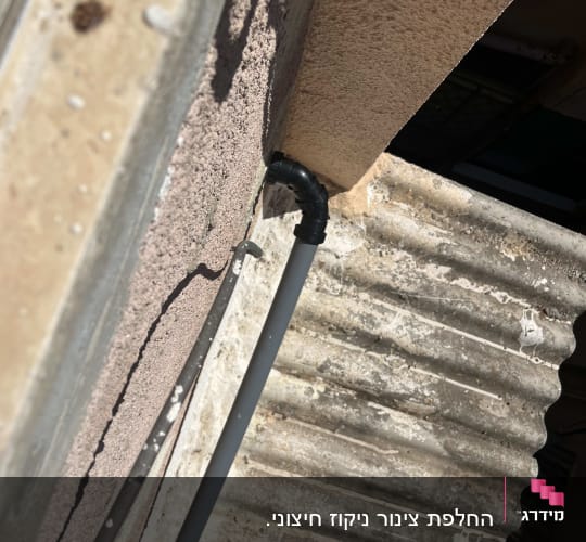 צינור מים מחובר לקיר חיצוני